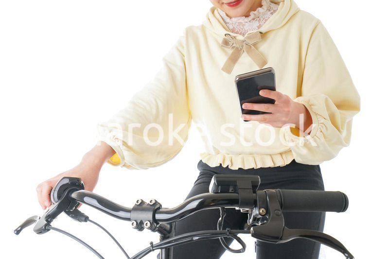 自転車でスマホを使う若い女性