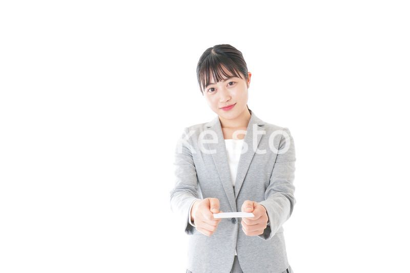 名刺を差し出す若いキャリアウーマン