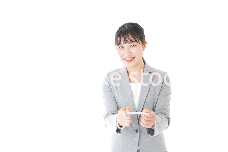 名刺を差し出す若いキャリアウーマン