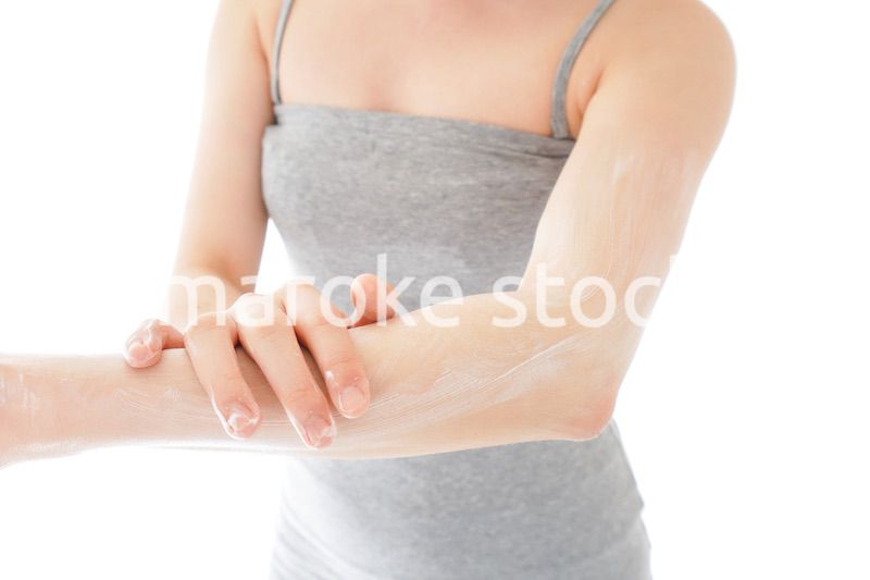 日焼け止めクリームを塗る若い女性