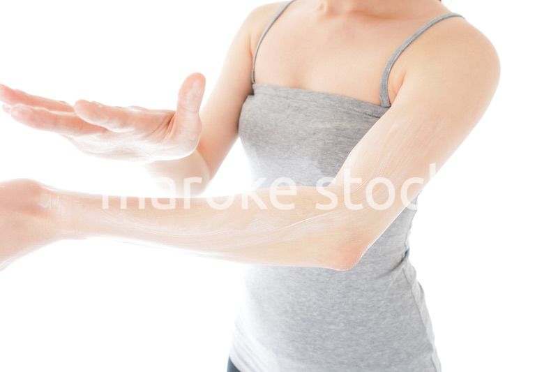 日焼け止めクリームを塗る若い女性