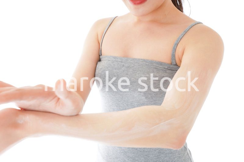 日焼け止めクリームを塗る若い女性