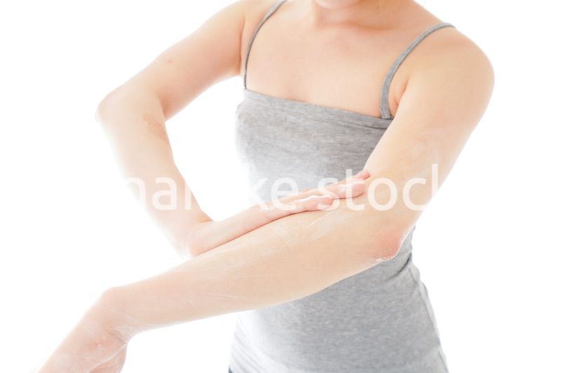 日焼け止めクリームを塗る若い女性