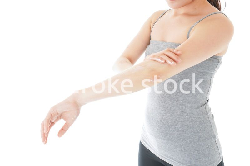 日焼け止めクリームを塗る若い女性