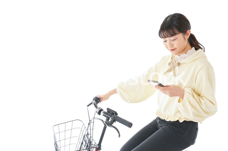 自転車でスマホを使う若い女性