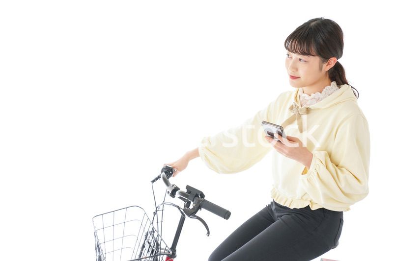自転車でスマホを使う若い女性