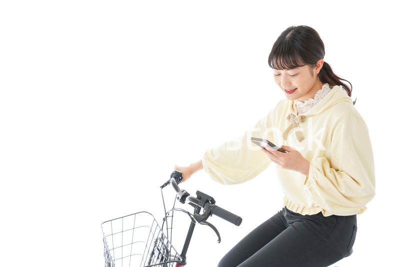 自転車でスマホを使う若い女性