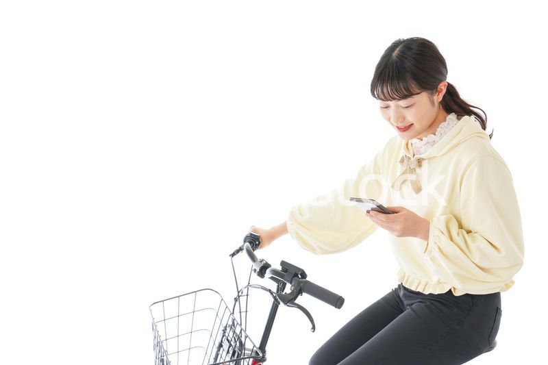 自転車でスマホを使う若い女性