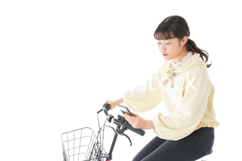 自転車でスマホを使う若い女性