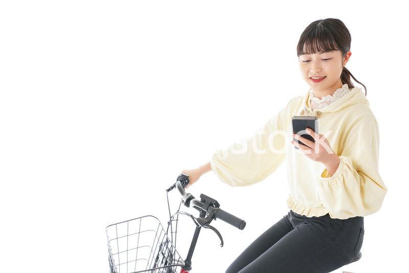 自転車でスマホを使う若い女性