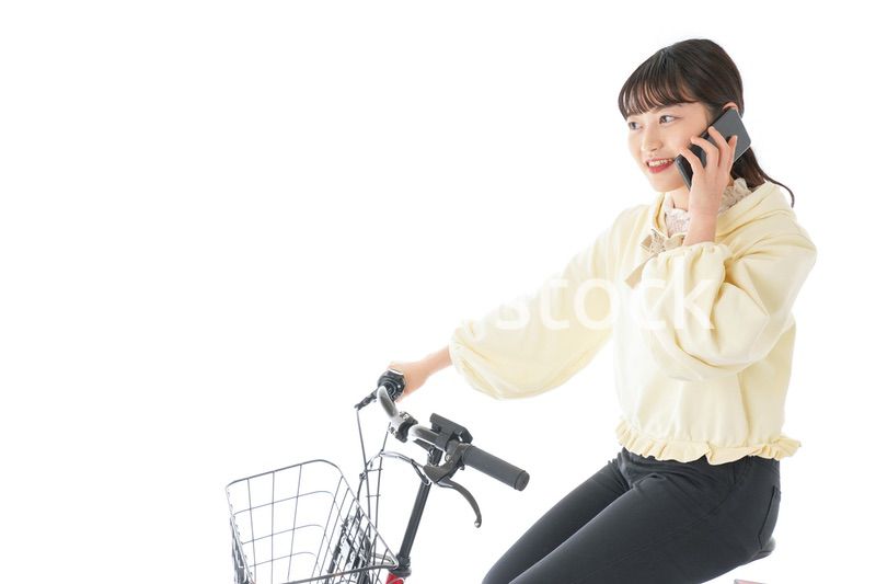 自転車でスマホを使う若い女性