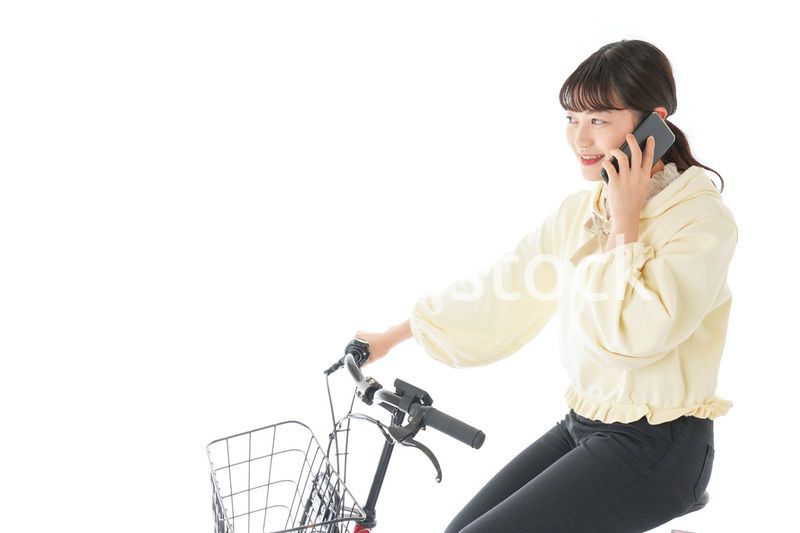 自転車でスマホを使う若い女性