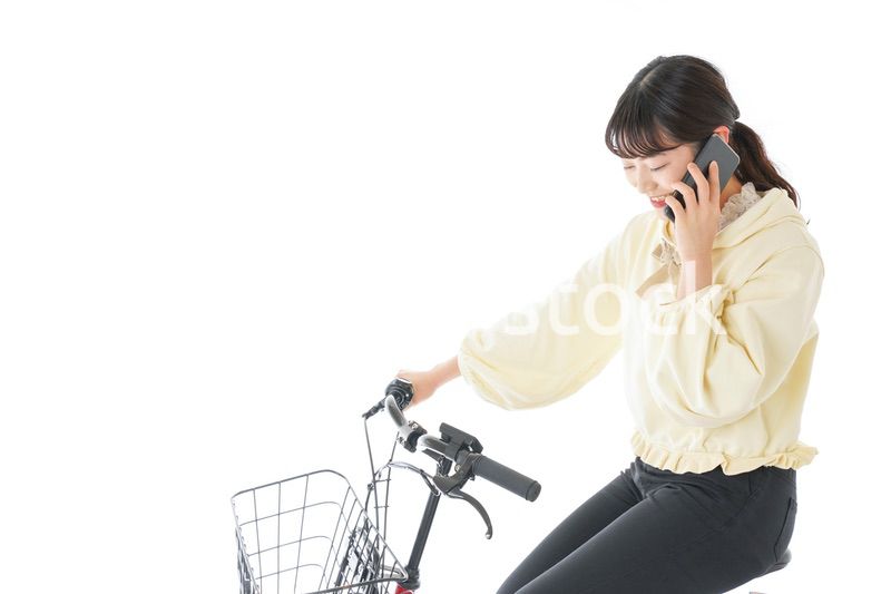 自転車でスマホを使う若い女性