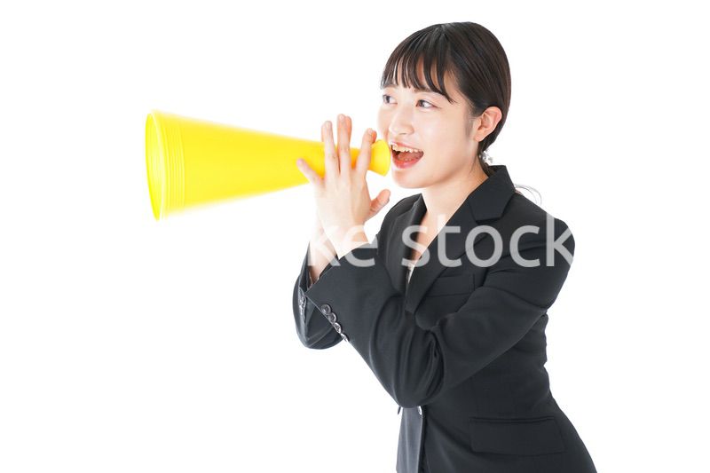 メガフォンで応援をするスーツを着たビジネスウーマン