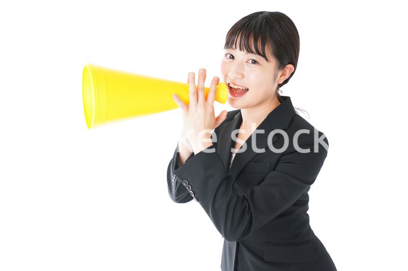 メガフォンで応援をするスーツを着たビジネスウーマン