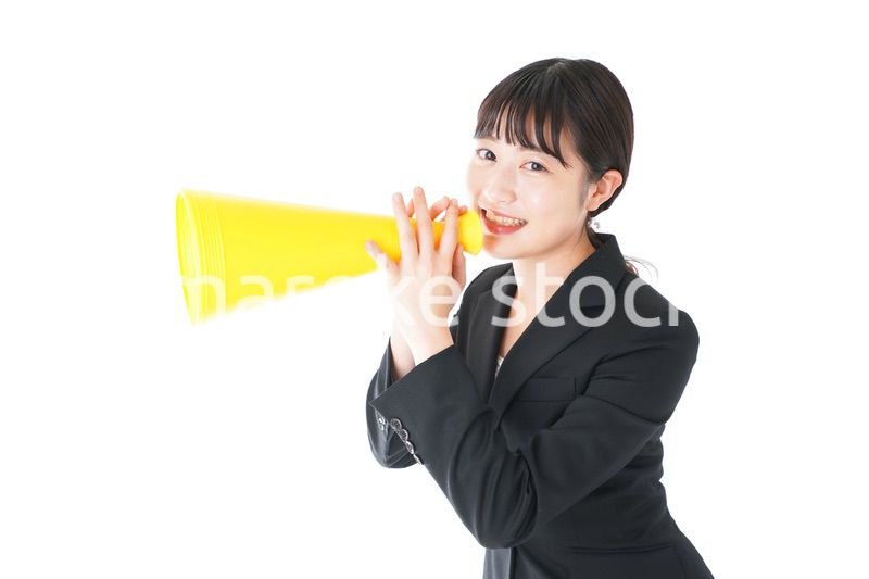 メガフォンで応援をするスーツを着たビジネスウーマン