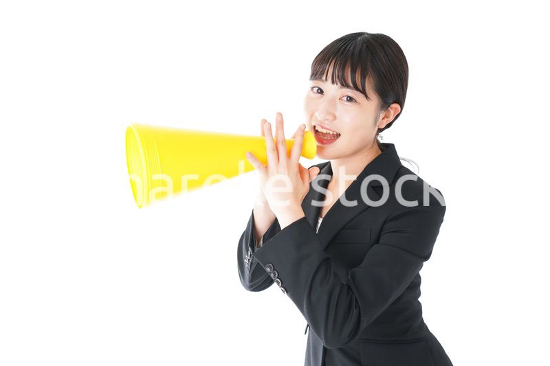 メガフォンで応援をするスーツを着たビジネスウーマン