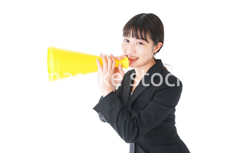 メガフォンで応援をするスーツを着たビジネスウーマン