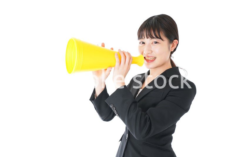 メガフォンで応援をするスーツを着たビジネスウーマン