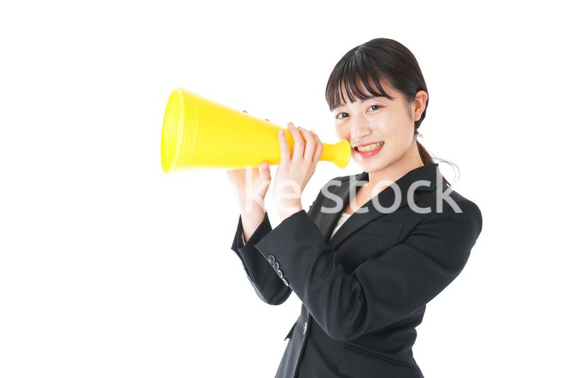 メガフォンで応援をするスーツを着たビジネスウーマン