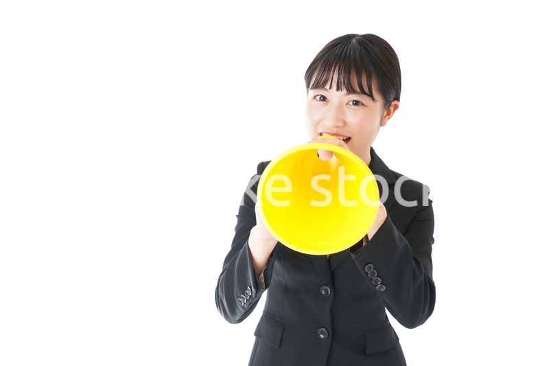 メガフォンで応援をするスーツを着たビジネスウーマン