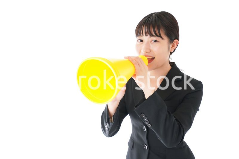 メガフォンで応援をするスーツを着たビジネスウーマン