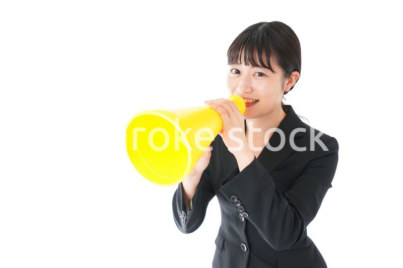 メガフォンで応援をするスーツを着たビジネスウーマン