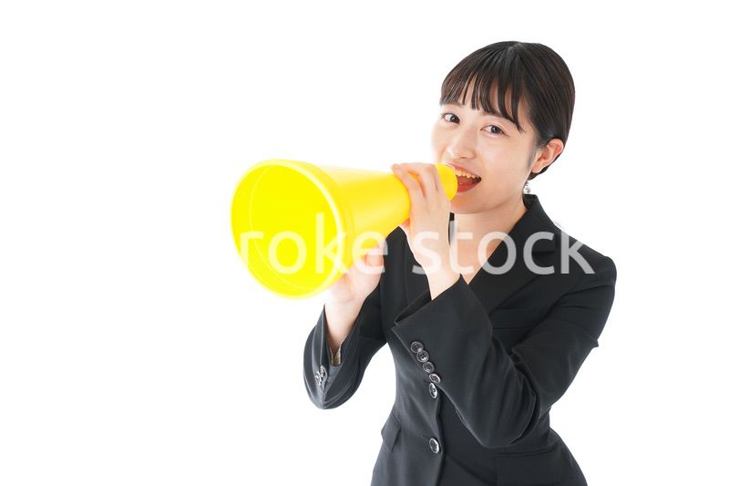 メガフォンで応援をするスーツを着たビジネスウーマン