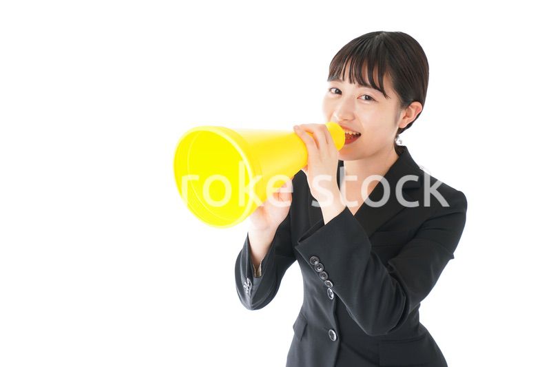 メガフォンで応援をするスーツを着たビジネスウーマン
