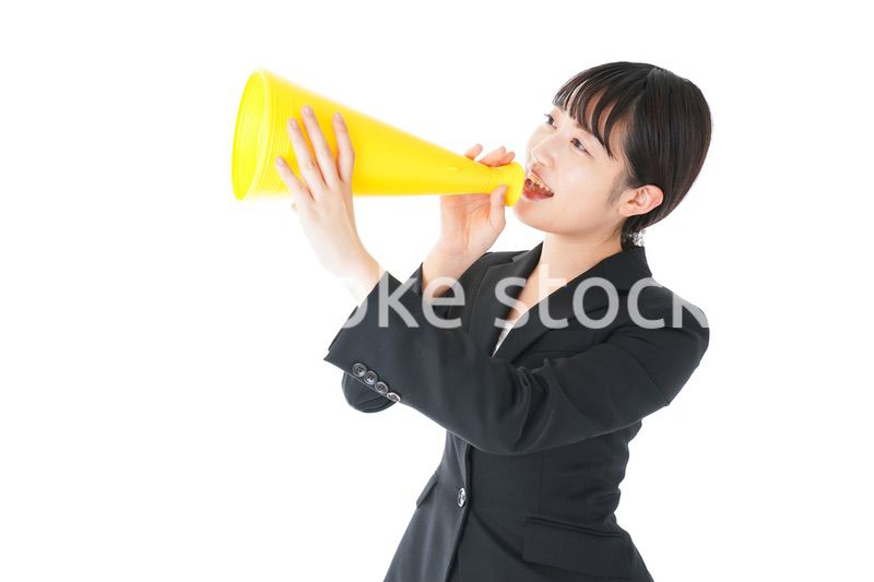 メガフォンで応援をするスーツを着たビジネスウーマン