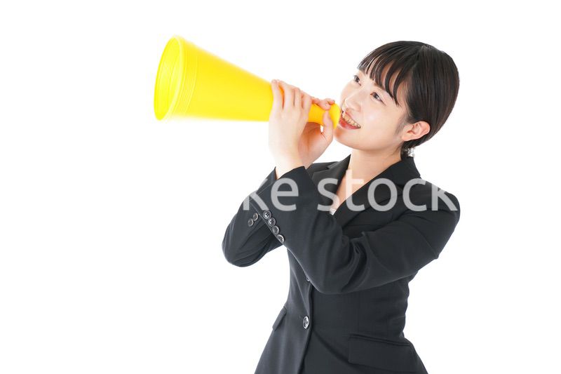 メガフォンで応援をするスーツを着たビジネスウーマン
