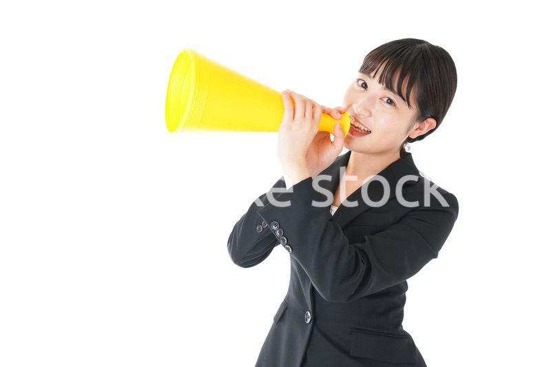 メガフォンで応援をするスーツを着たビジネスウーマン