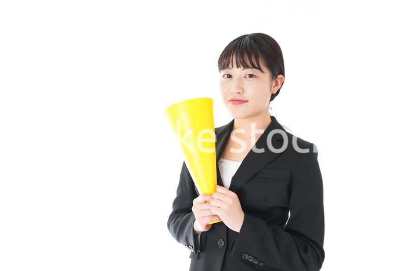 メガフォンで応援をするスーツを着たビジネスウーマン