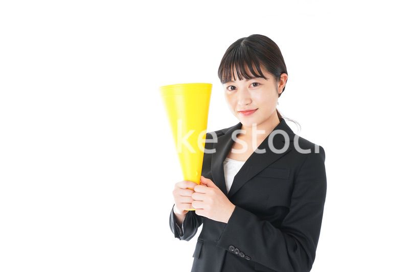 メガフォンで応援をするスーツを着たビジネスウーマン