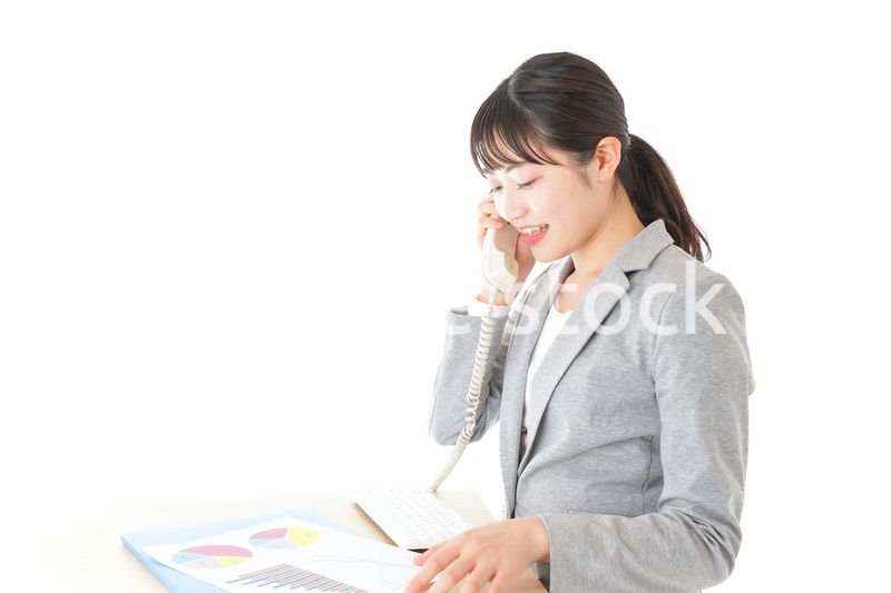 オフィスで固定電話を使う若いビジネスウーマン