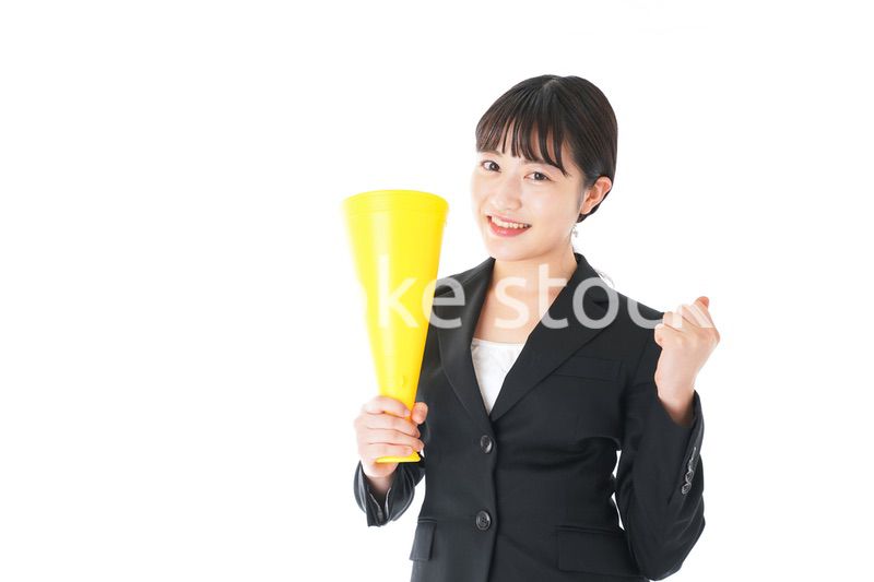 メガフォンで応援をするスーツを着たビジネスウーマン