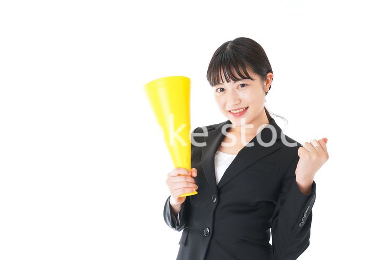 メガフォンで応援をするスーツを着たビジネスウーマン