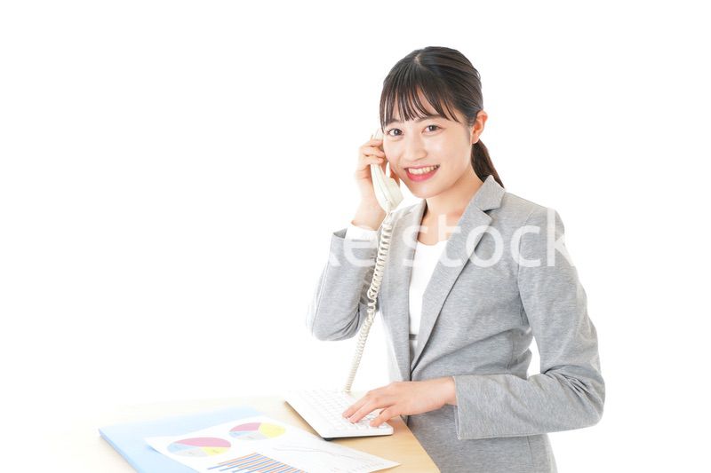 オフィスで固定電話を使う若いビジネスウーマン