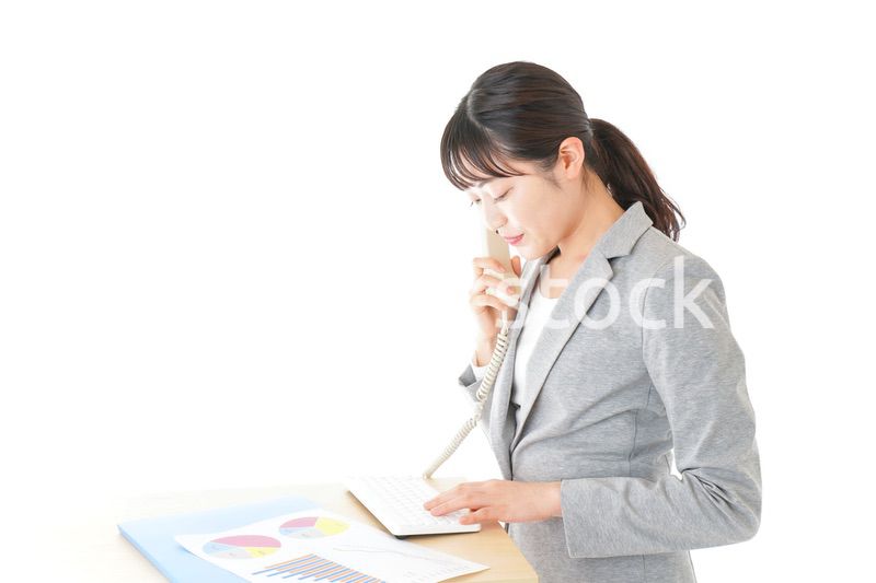 オフィスで固定電話を使う若いビジネスウーマン