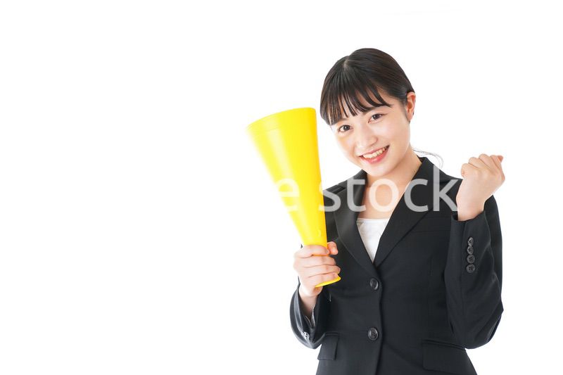 メガフォンで応援をするスーツを着たビジネスウーマン