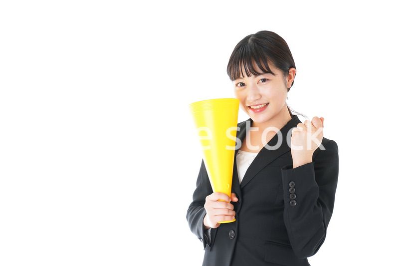 メガフォンで応援をするスーツを着たビジネスウーマン