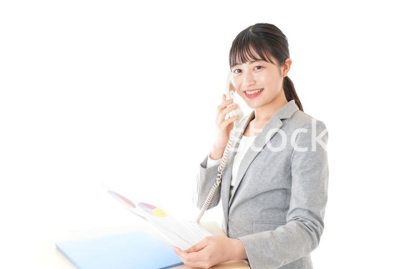 オフィスで固定電話を使う若いビジネスウーマン