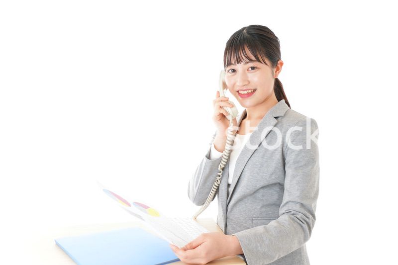 オフィスで固定電話を使う若いビジネスウーマン