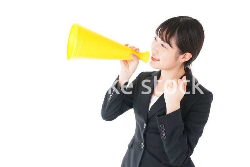 メガフォンで応援をするスーツを着たビジネスウーマン