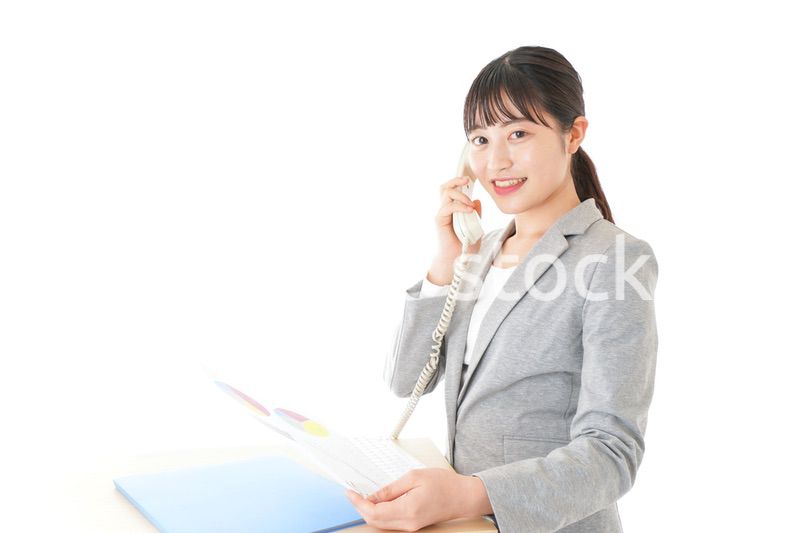 オフィスで固定電話を使う若いビジネスウーマン