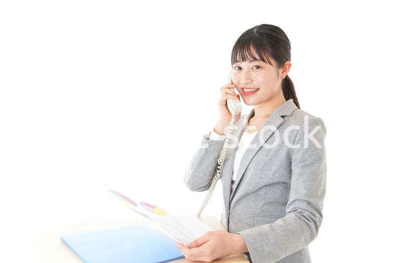 オフィスで固定電話を使う若いビジネスウーマン