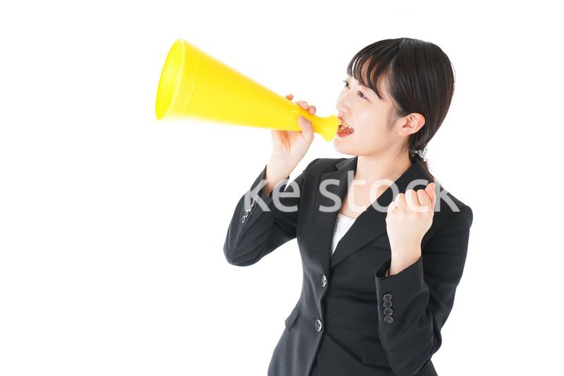 メガフォンで応援をするスーツを着たビジネスウーマン