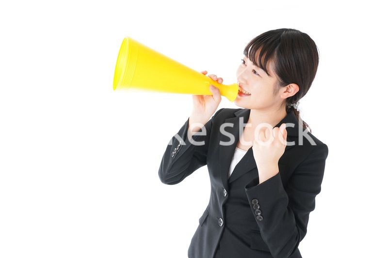 メガフォンで応援をするスーツを着たビジネスウーマン
