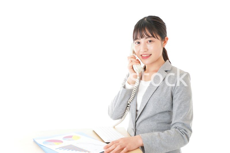 オフィスで固定電話を使う若いビジネスウーマン