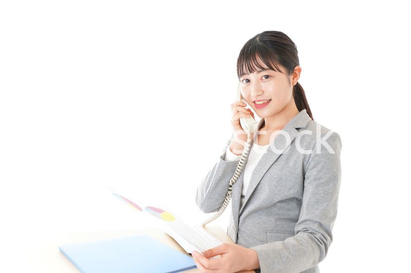 オフィスで固定電話を使う若いビジネスウーマン